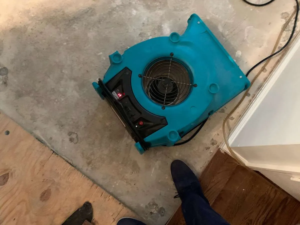 Air mover drying subfloor during Commercial Water Damage Restoration in Lee's Summit